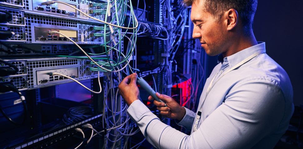 Focused data center employee checking cabling infrastructure
